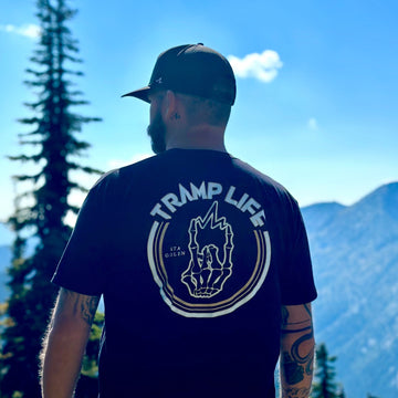 man standing with the stay golden shirt from tramp life. mountains and trees in background