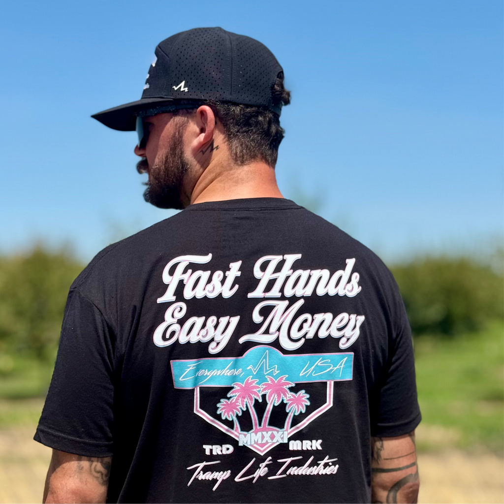 man wearing black shirt standing backwards that says fast hands easy money in miami vice colors