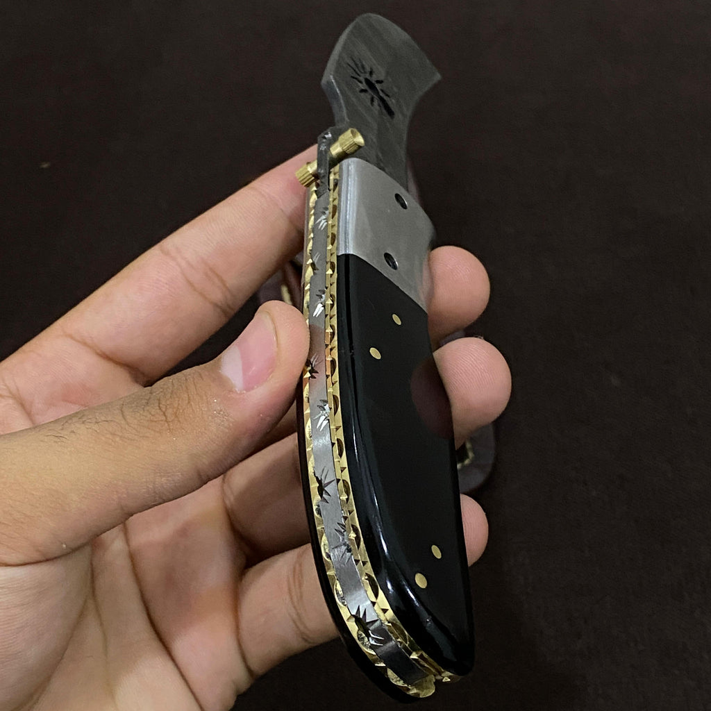 handle holding damascus steel knife with black handle