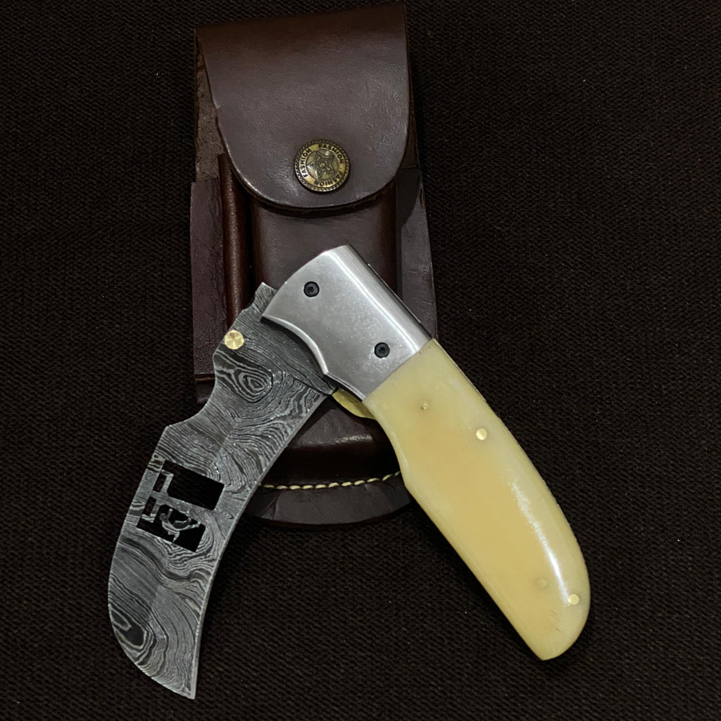 foldable hawks bill knife made of damascus steel and camel bone handle. 