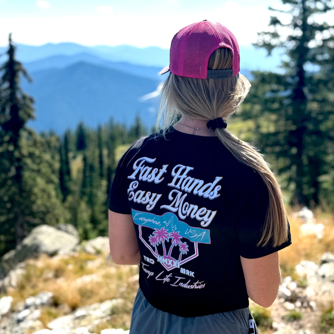 woman wearing a nd6f gold hat from tramp life standing in front of sullivan lake