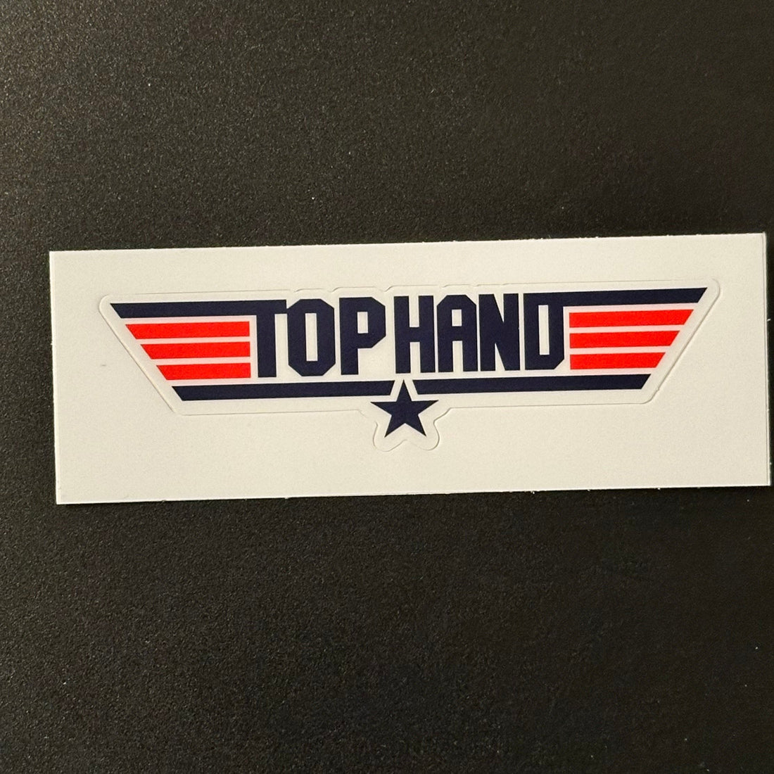 Rectangular sticker with 'Tophand' logo on a black background