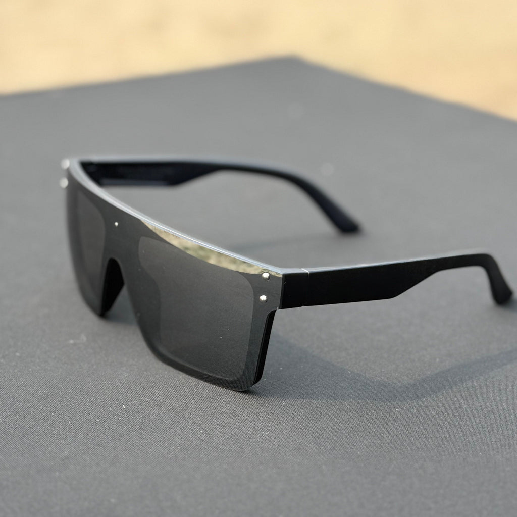 Black sunglasses on a gray surface with a blurred background