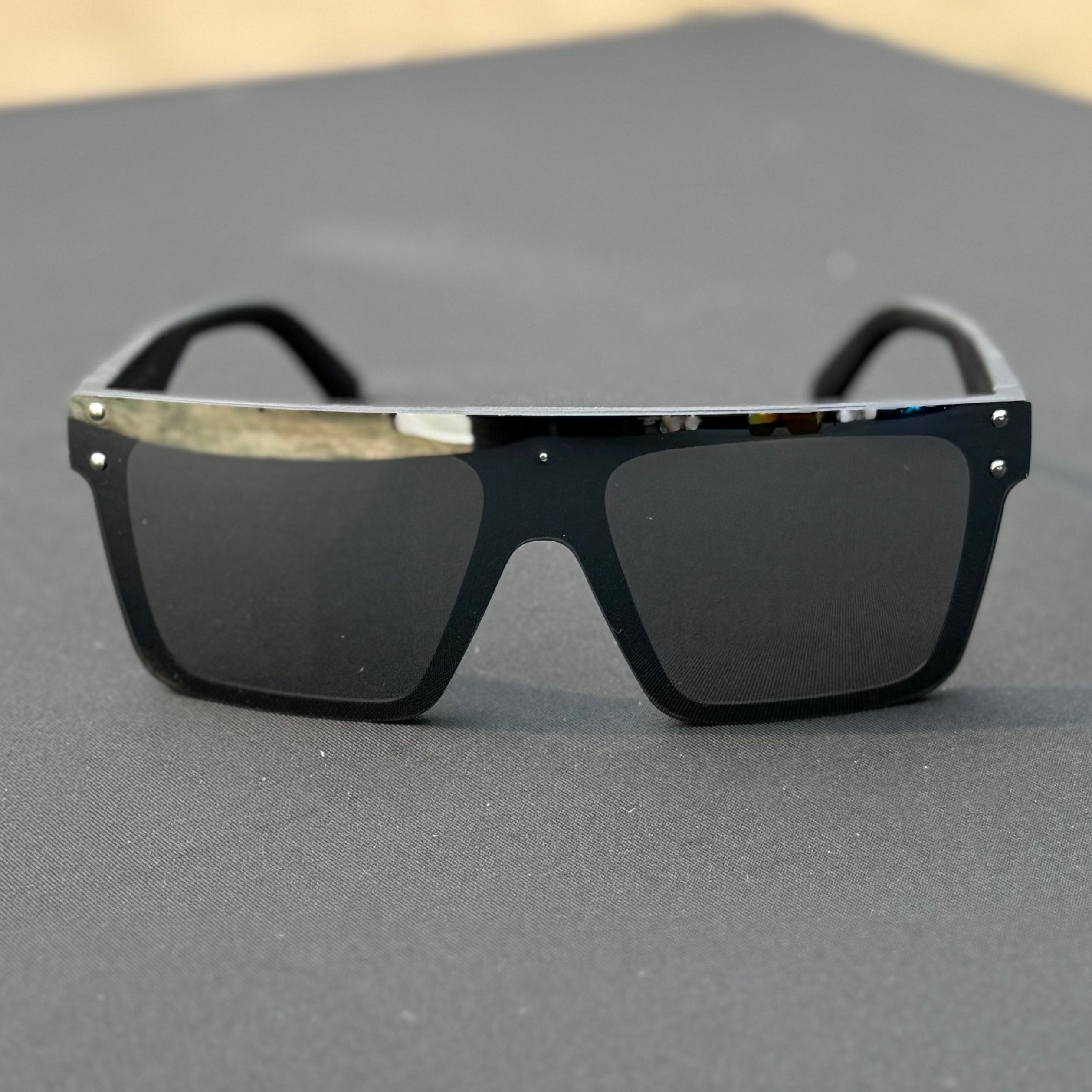 Black sunglasses on a gray surface with a blurred background