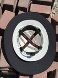 a close up of an all black sunshade on a white hard hat turned upside down showing the inside of the hard hat