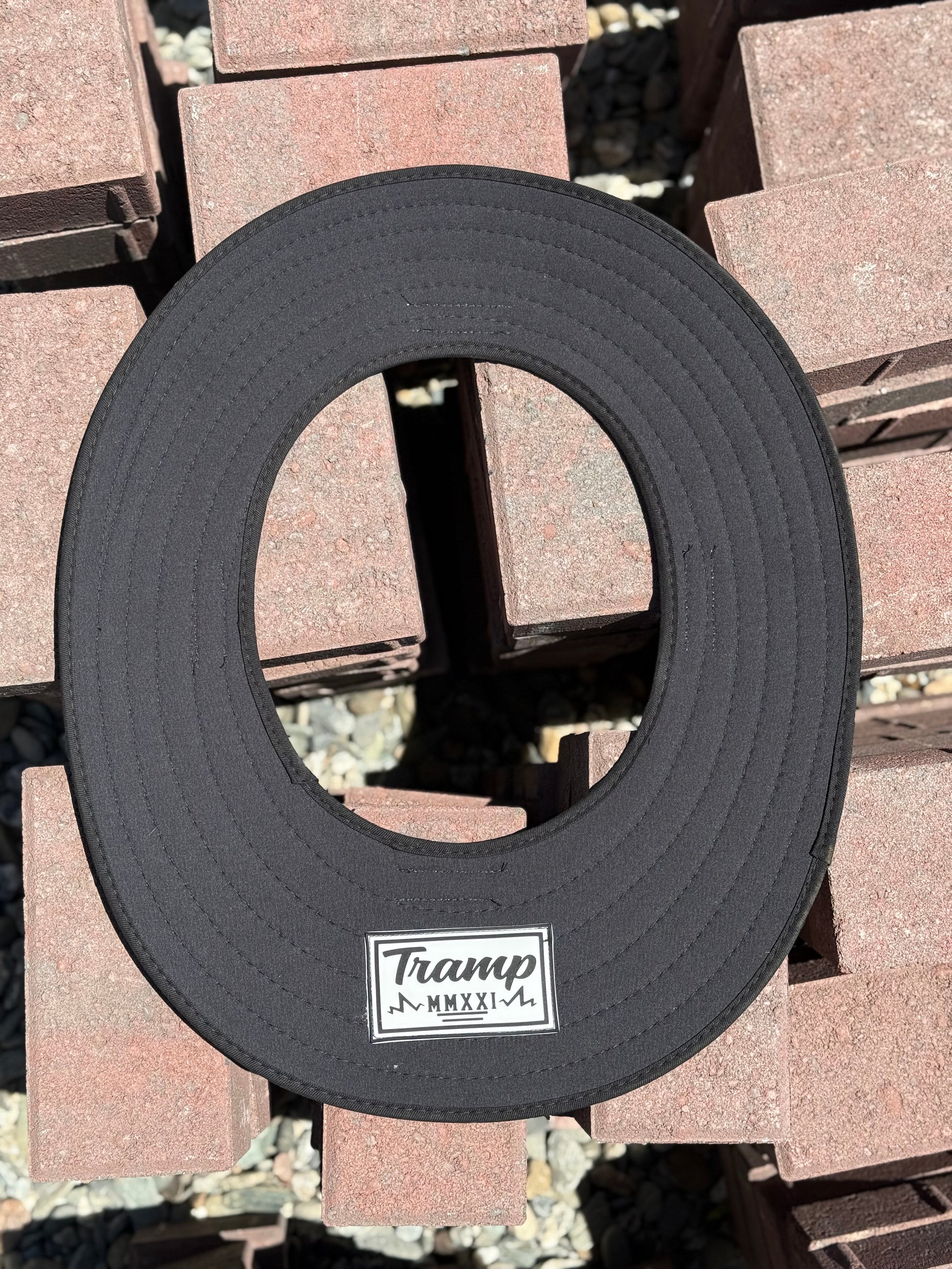 An all-black sunshade from tramp life industries with a PVC patch sewn into it with the words TRAMP
