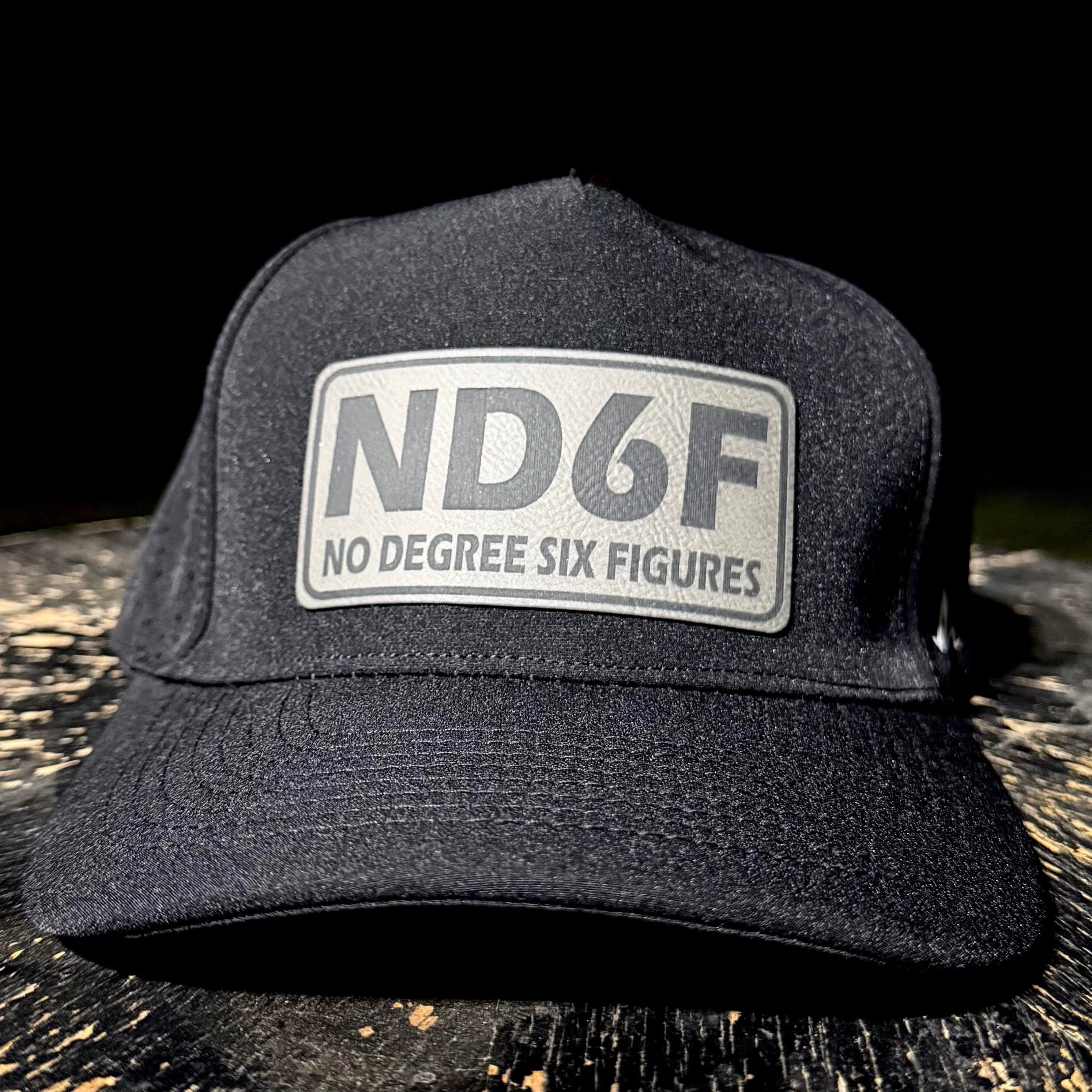 Black cap with 'ND6F No Degree Six Figures' logo on a dark surface