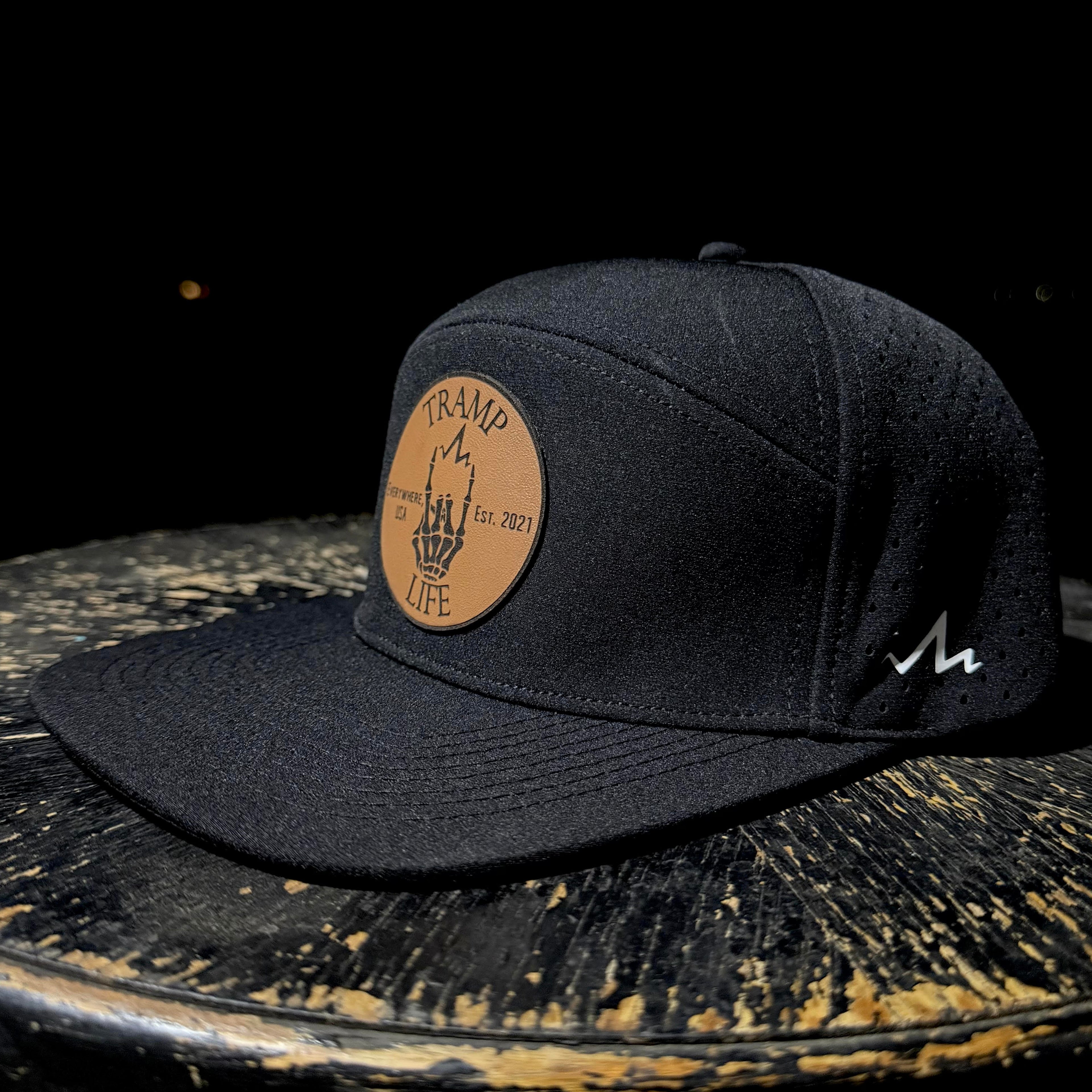 Black cap with a leather patch on a rustic wooden surface