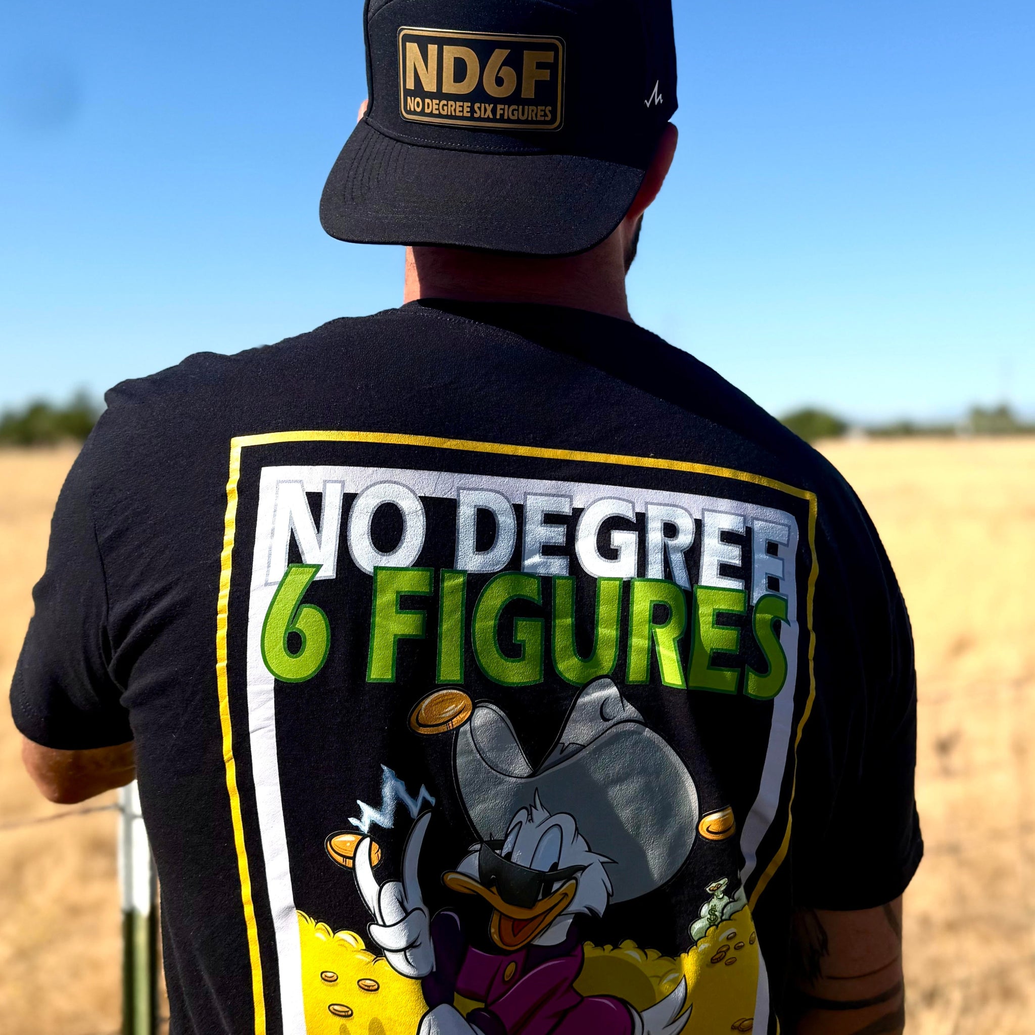 man wearing no degree duck shirt standing in a field
