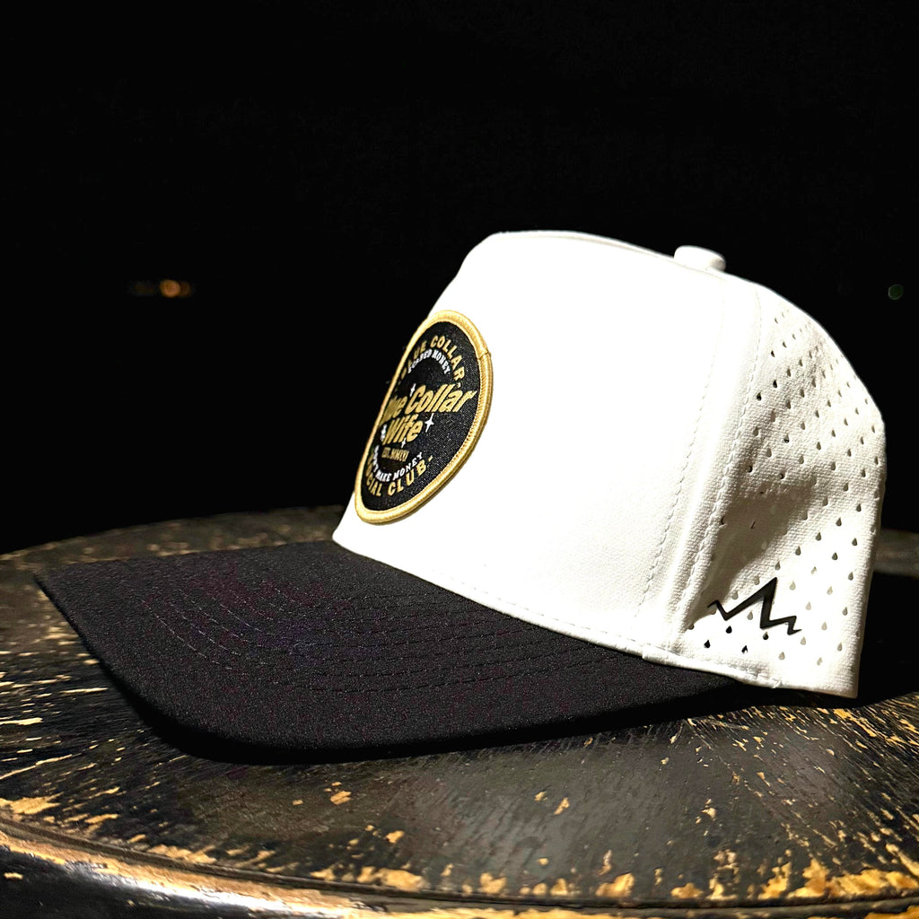 White and black cap with a logo on a dark surface
