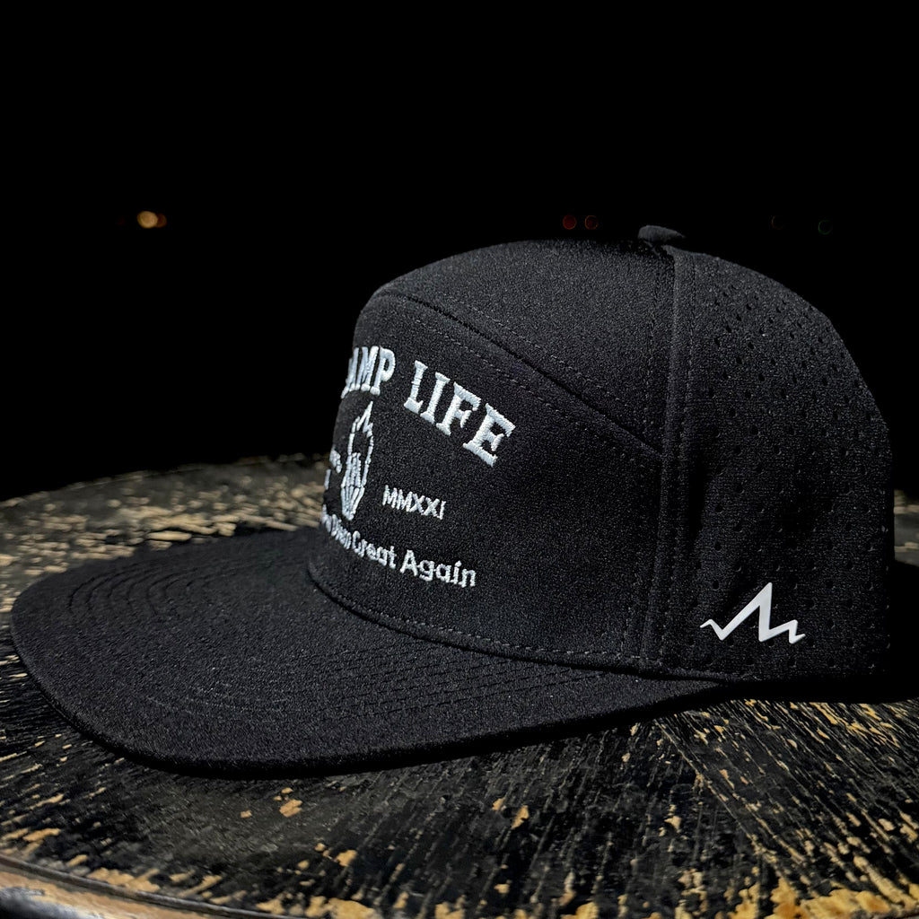 Black cap with white text and logo on a dark surface