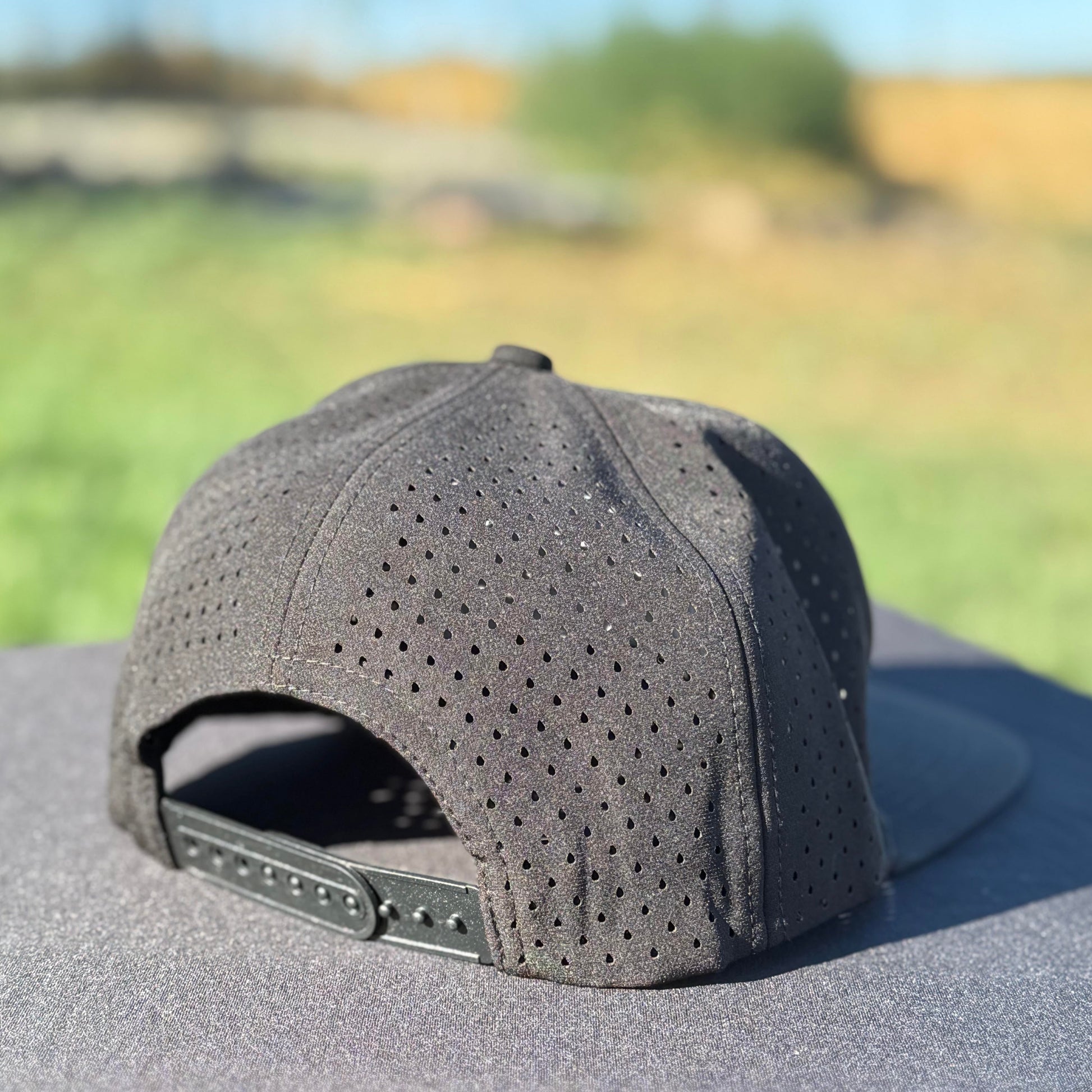 the back of ablack embroidered snapback water resistant hat with tramp life, a bone hand, make per diem great again for blue collar workers