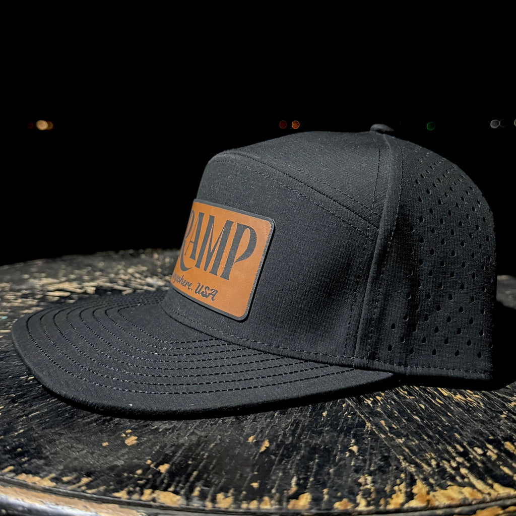 Black cap with a brown leather patch on a dark surface