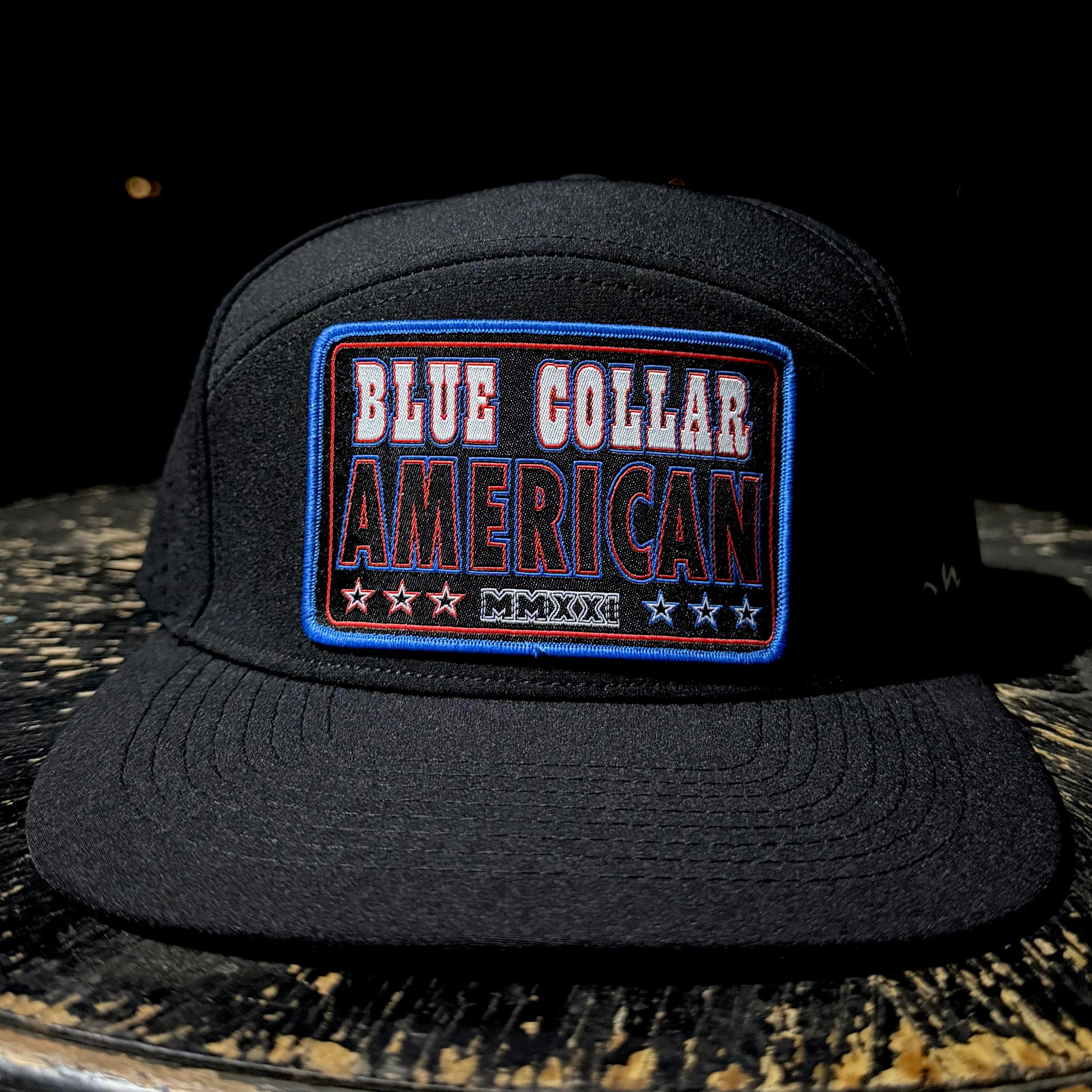 Black cap with 'Blue Collar American' patch on a dark surface