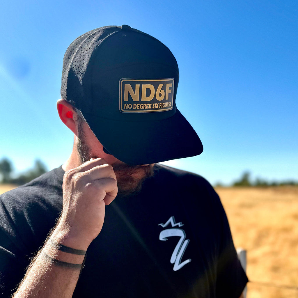 a person wearing a gold ND6F hat standing in a field
