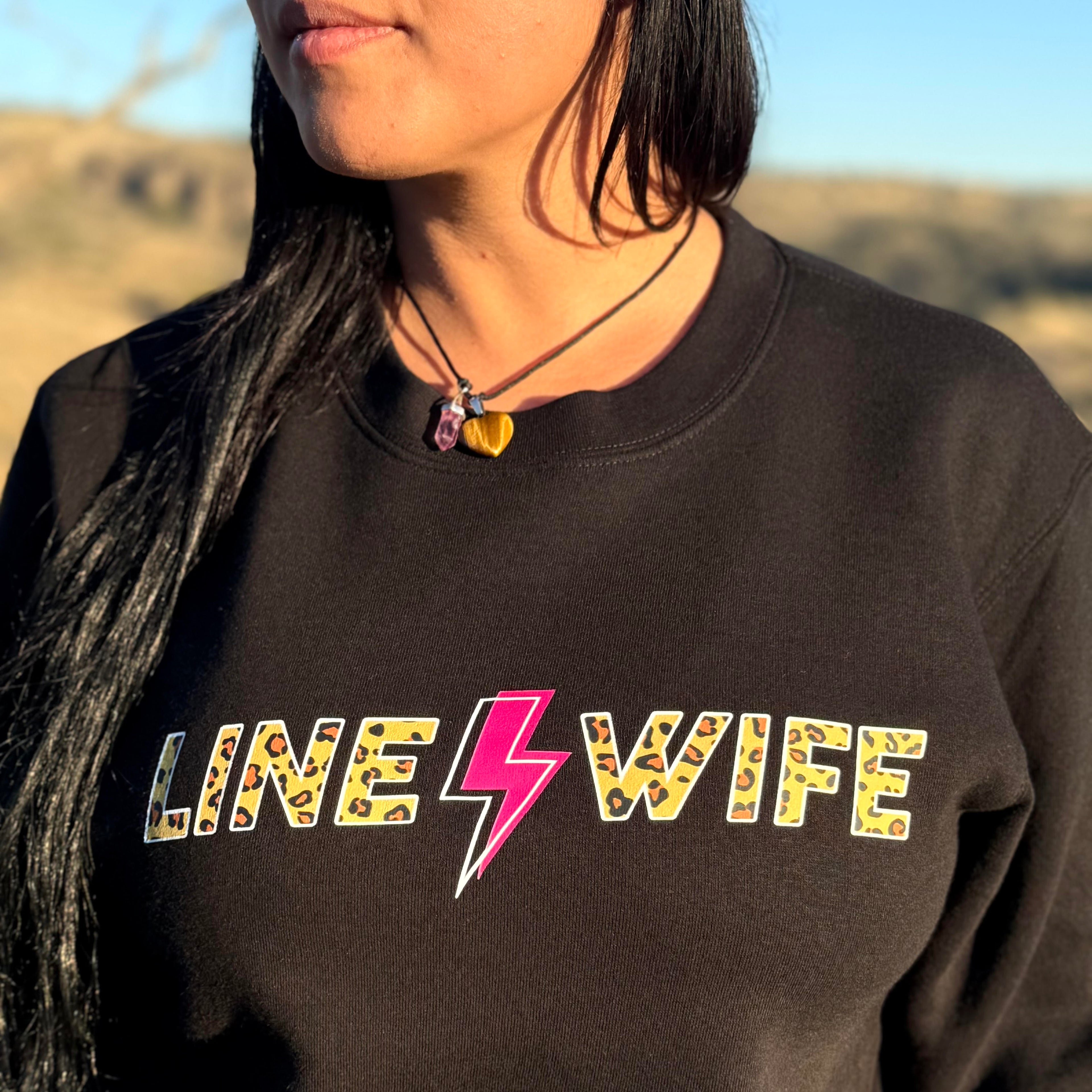 woamn wearing sweatshirt from tramp life that says line wife in cheetah print. there is a pink and white lightning bolt in the middle