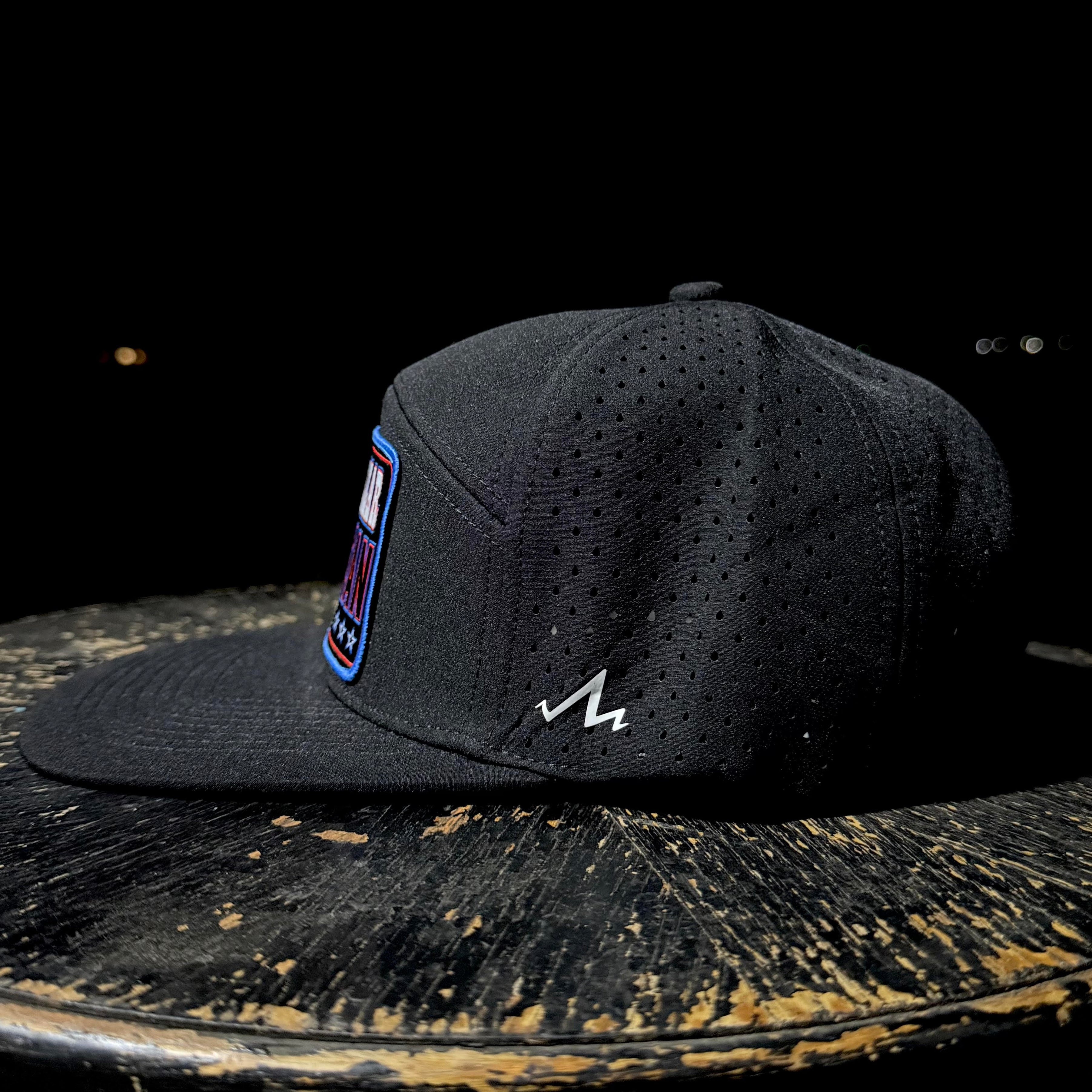 Black cap with a logo on a dark surface