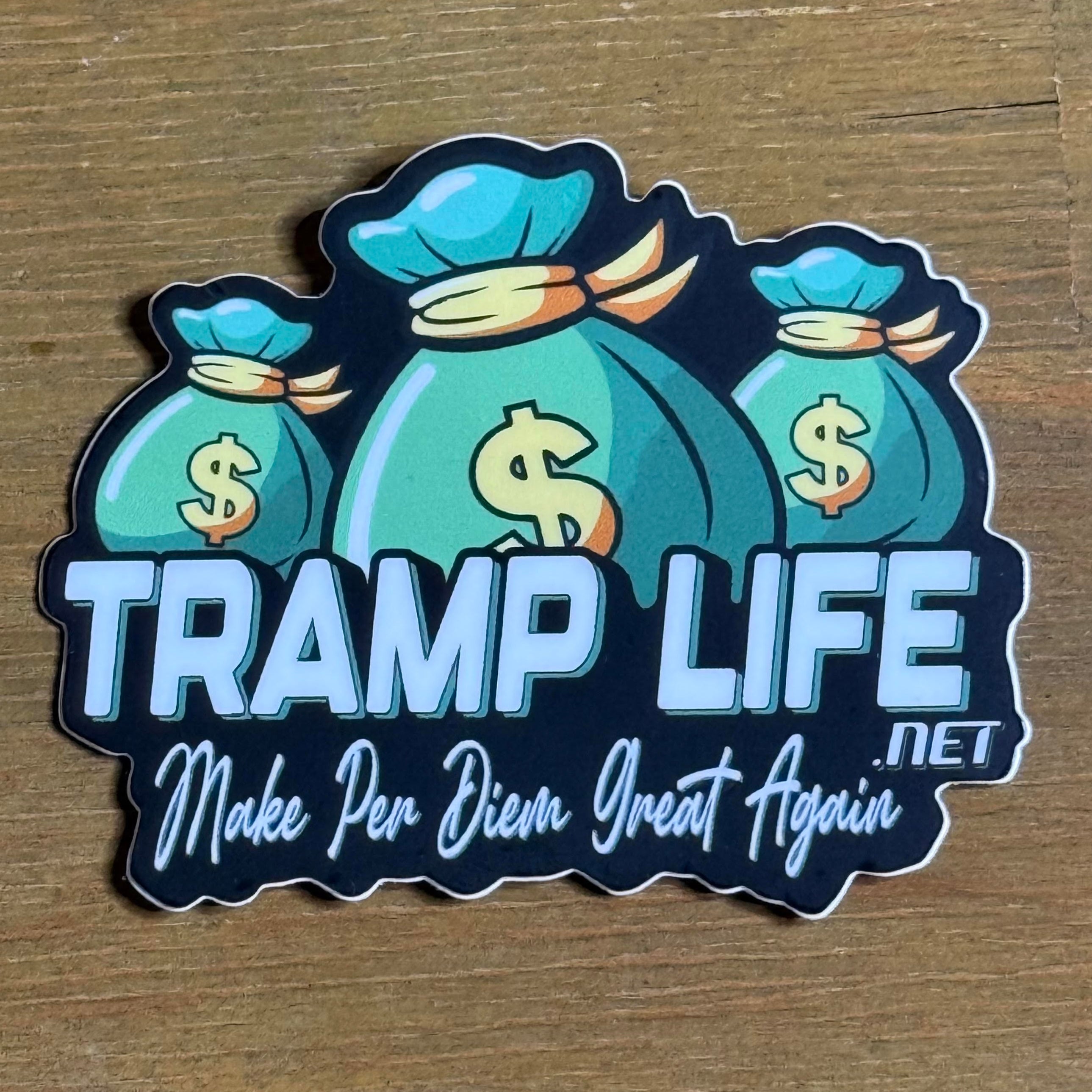 Sticker with money bags and text 'TRAMP LIFE Make Per Diem Great Again' on a wooden surface