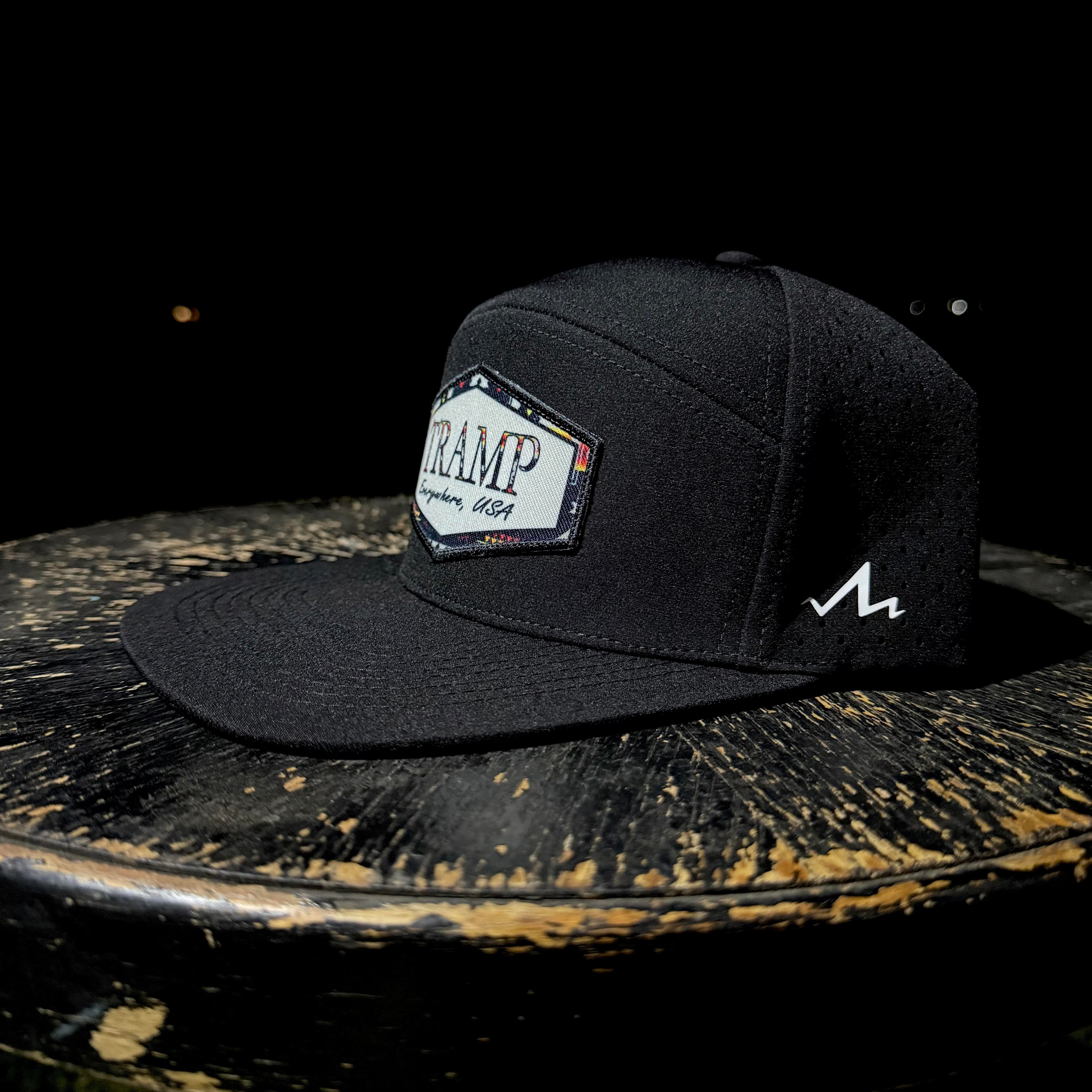 Black cap with a logo on a dark surface