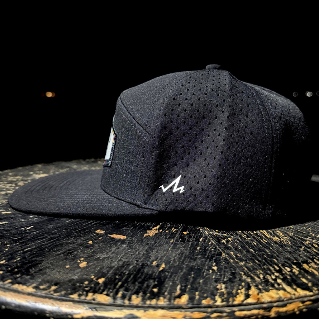 Black cap with a logo on a rustic wooden surface