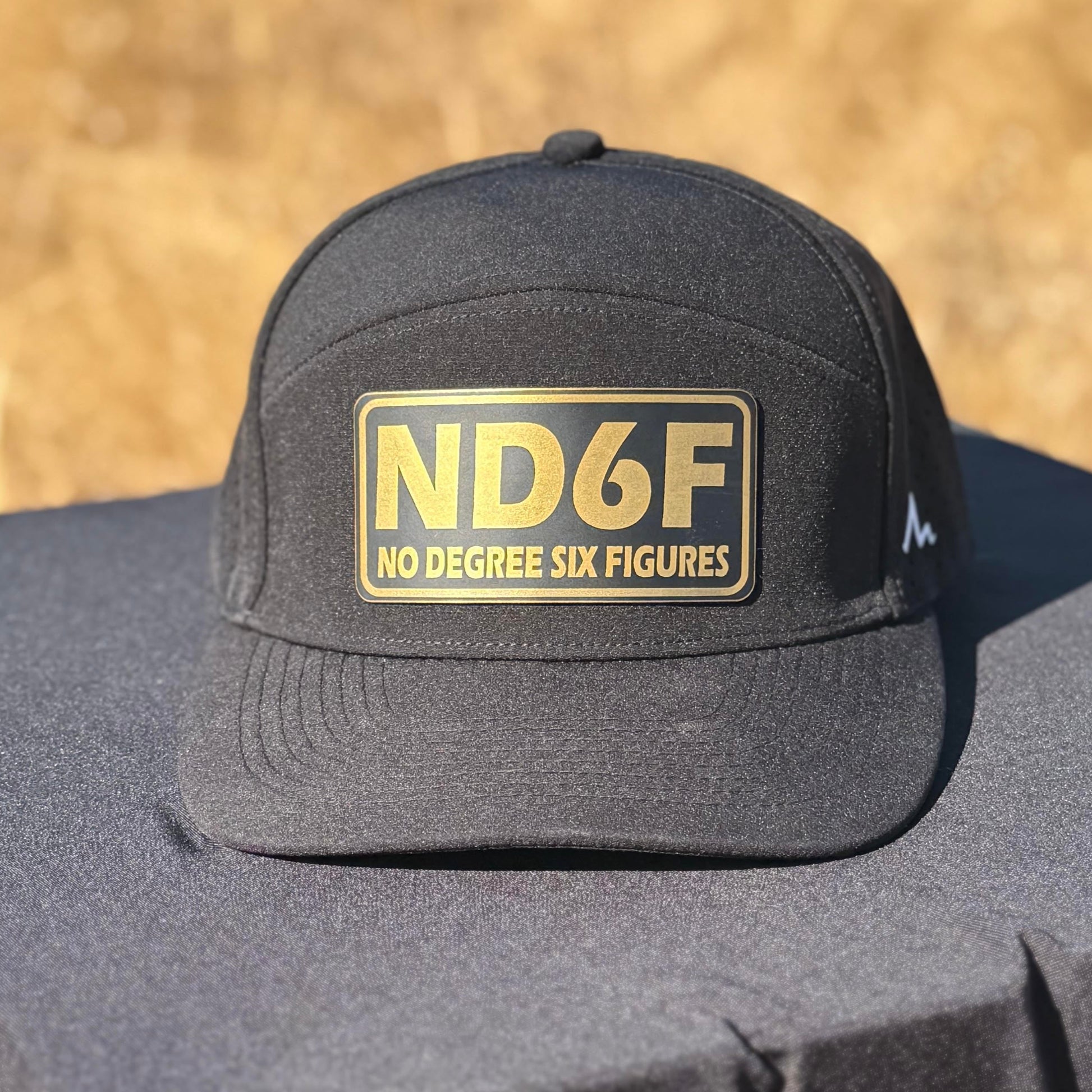 Black cap with 'ND6F' logo on a black surface with a blurred natural background