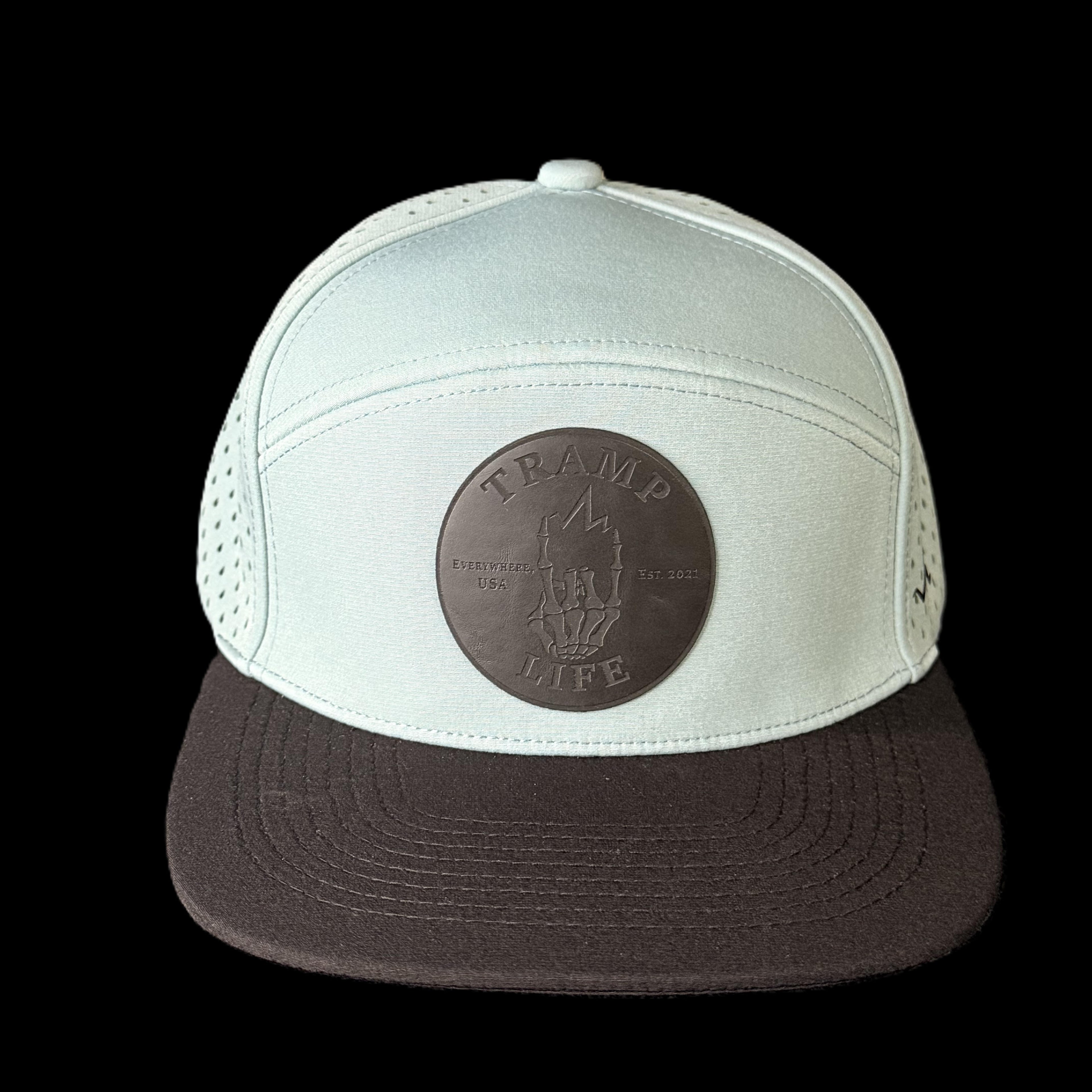 stone blue hydro nomad from tramp life with a black bill and black leather logo
