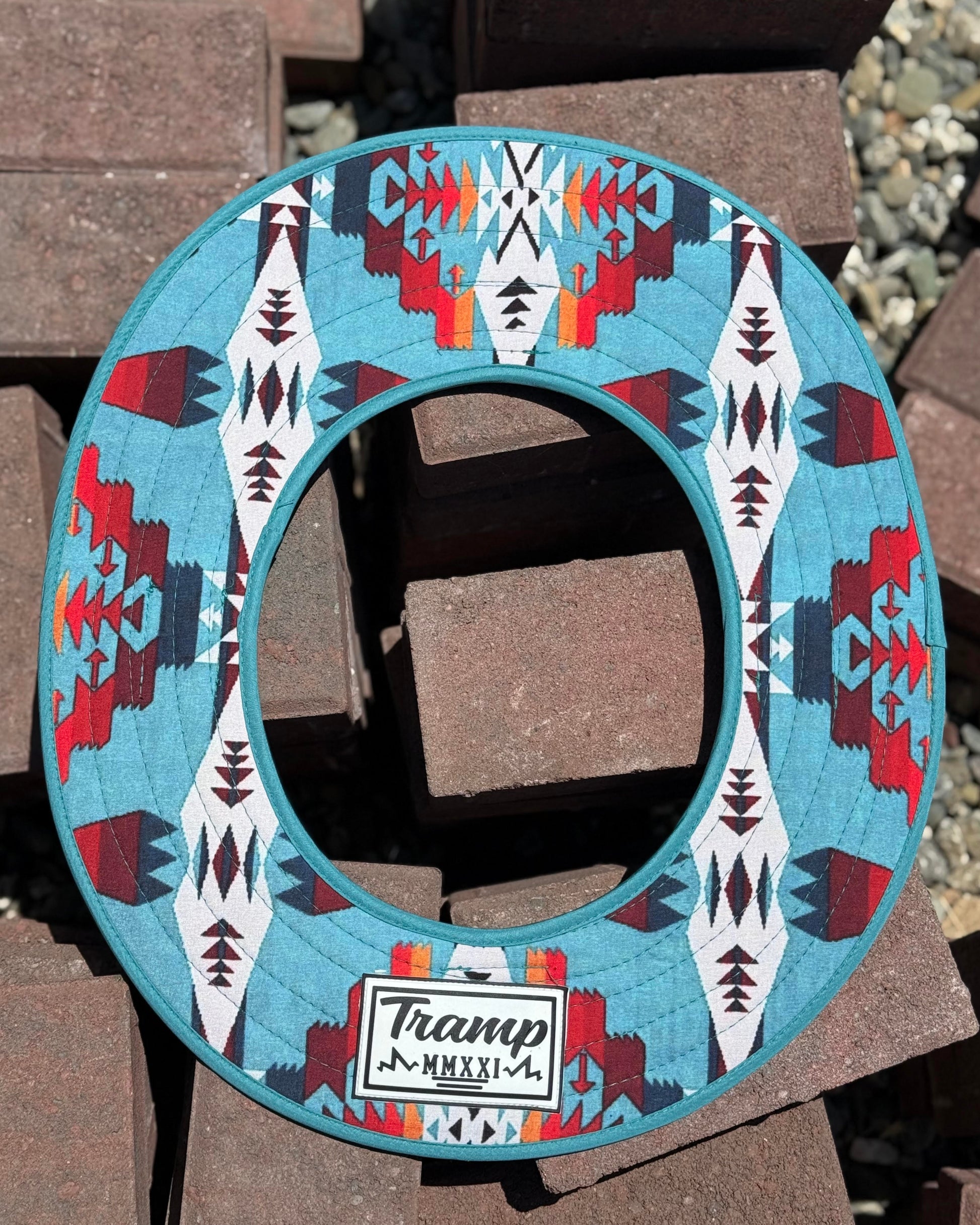 the top side of a turquoise sunshade with red, yellow, white and navy accents from tramp life industries