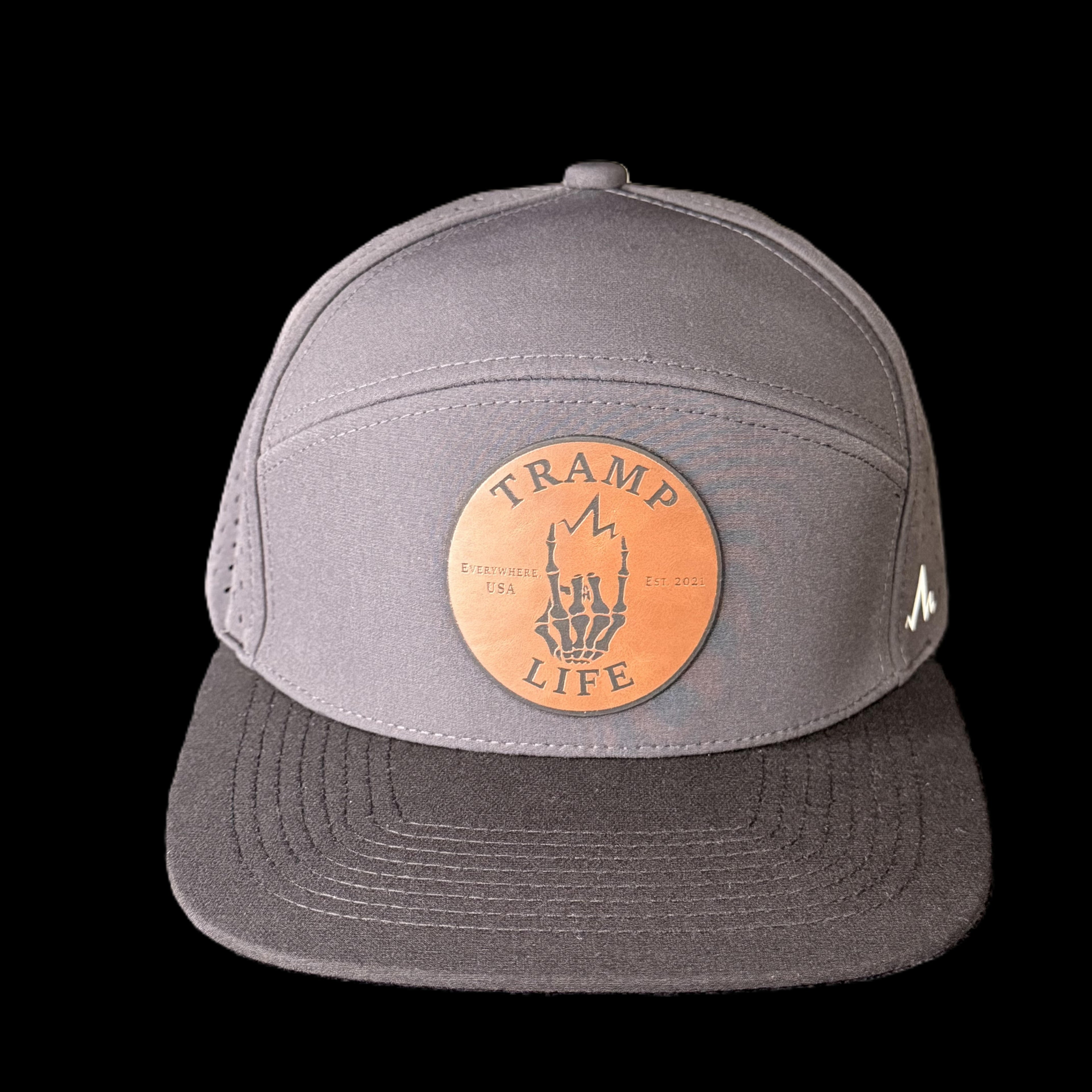 Gray cap with orange patch featuring 'Tramp Life' design on a black background