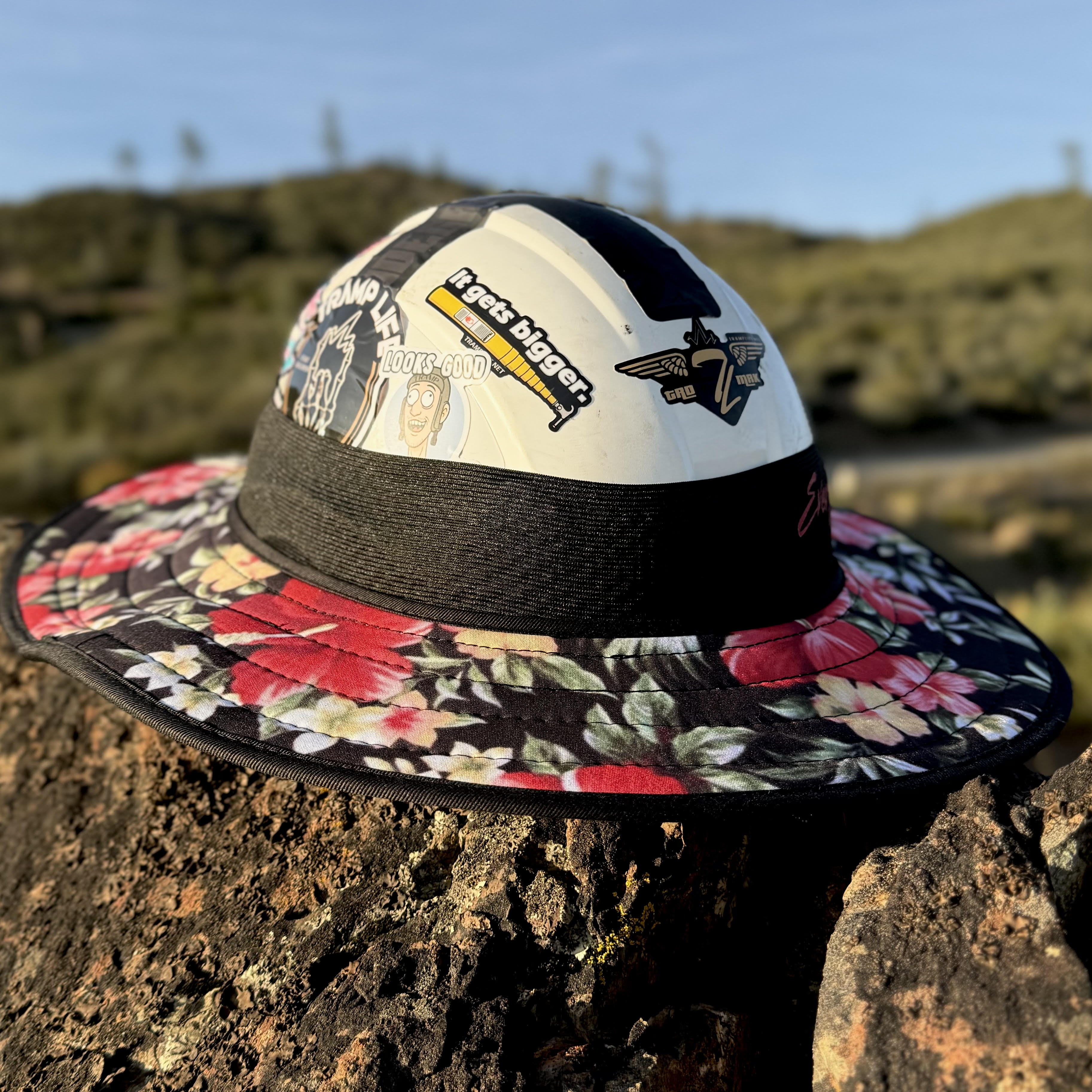 the aloha fly shade from tramp life industries, has pink hibiscus flowers on it. sitting on a rock